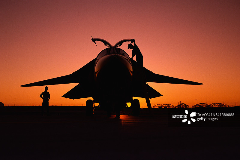 日落时分检查F-111的技工图片素材