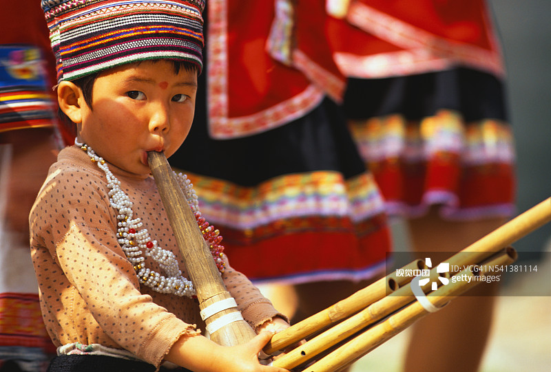 苗族男孩演奏竹制乐器图片素材
