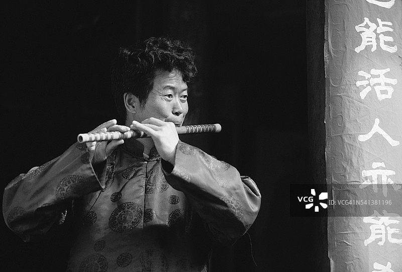 纳西族音乐家吹奏笛子图片素材