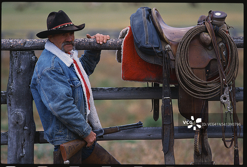 站在马鞍旁的牛仔图片素材