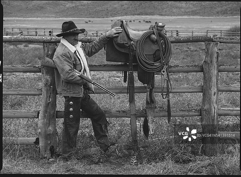 牛仔倚靠在栅栏上图片素材