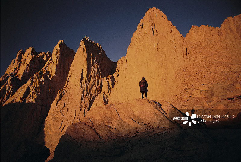 日出时攀登惠特尼峰的登山者图片素材