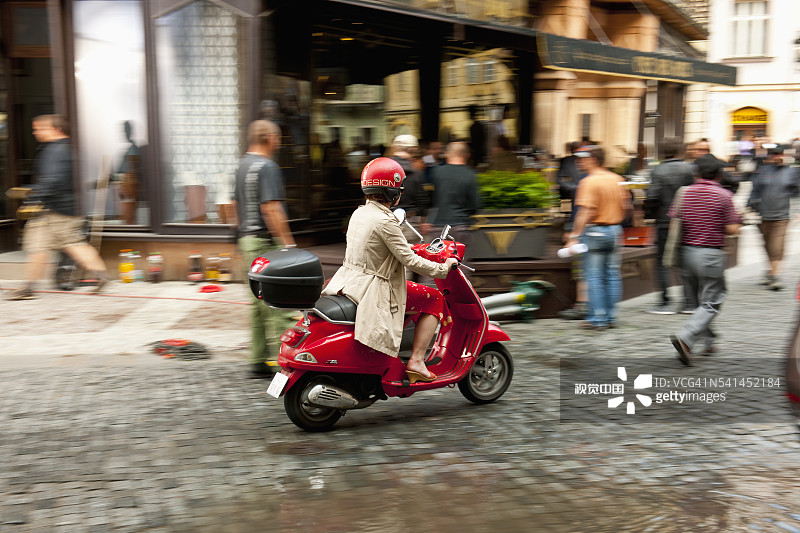 在捷克共和国布拉格 Celetna 街骑滑板车的女人图片素材