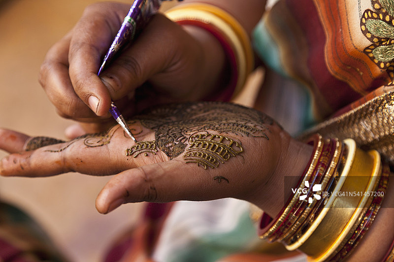 女人在手上涂上海娜纹饰图片素材