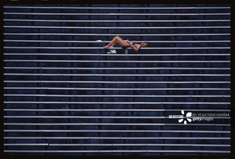 在体育场看台上享受日光浴的人图片素材