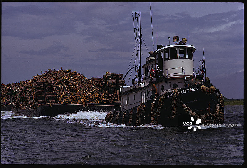 拖船拖着装满原木的驳船图片素材
