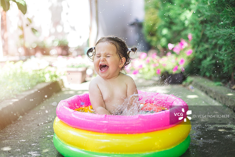 一岁宝宝在婴儿游泳池里玩耍图片素材