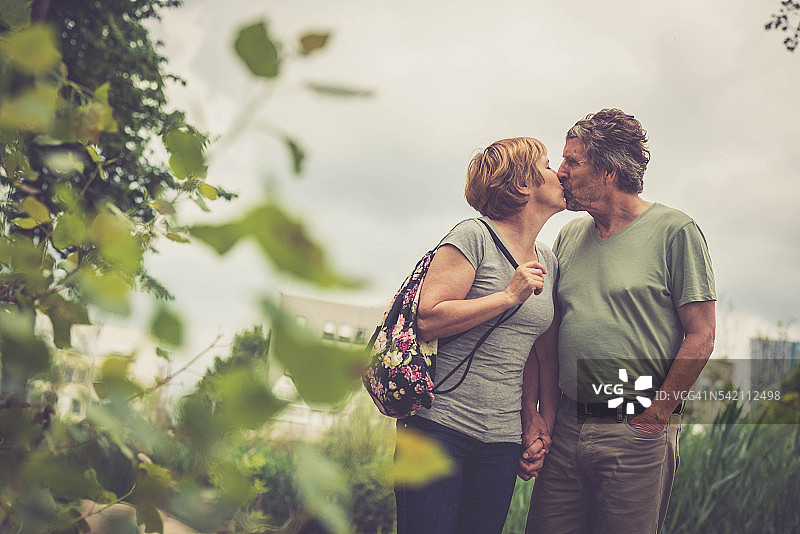 年长的白人夫妇在户外亲吻、牵手和拥抱图片素材