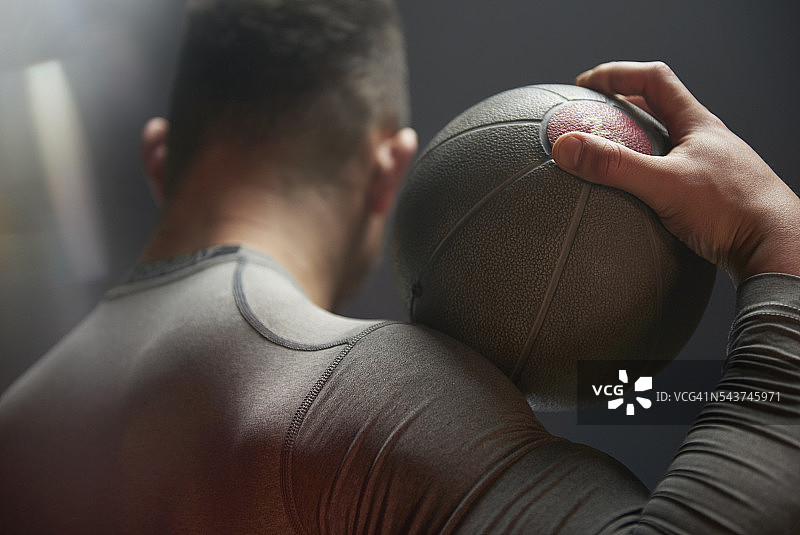 在工业环境中锻炼的男运动员，手持药球图片素材