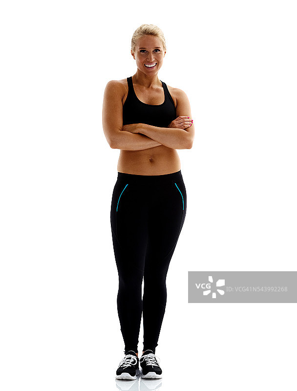 微笑的运动女人交叉双臂站立图片素材