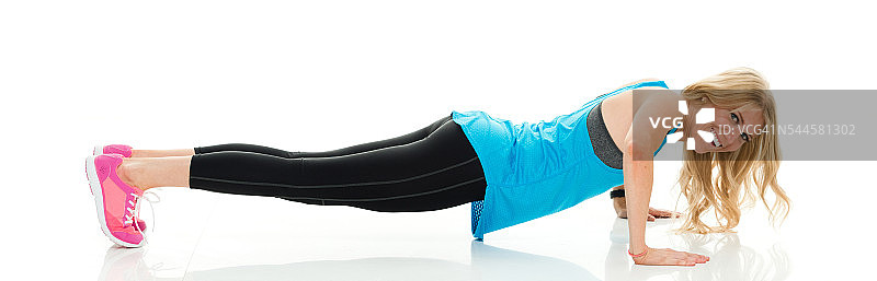 快乐的运动女人做俯卧撑图片素材