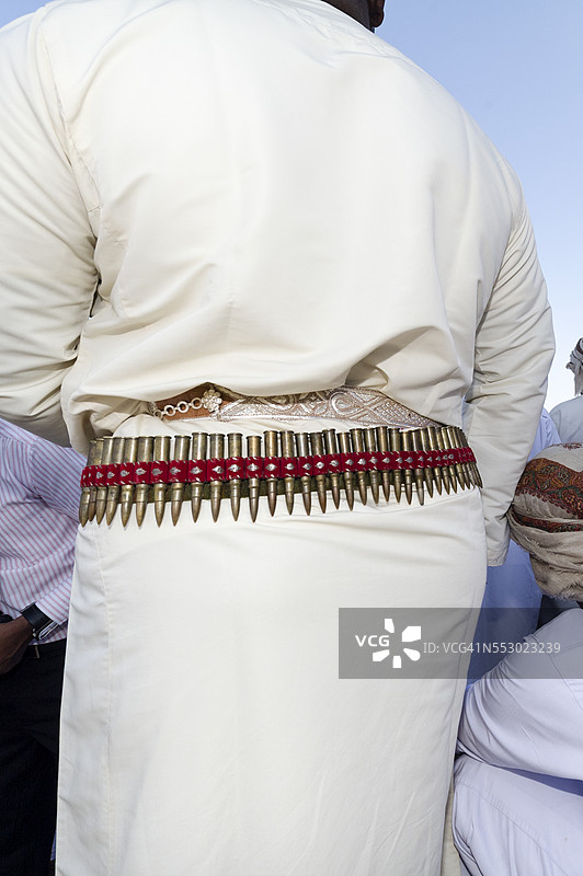 在骆驼赛跑活动中，子弹带装饰着一位骑手的腰带。图片素材