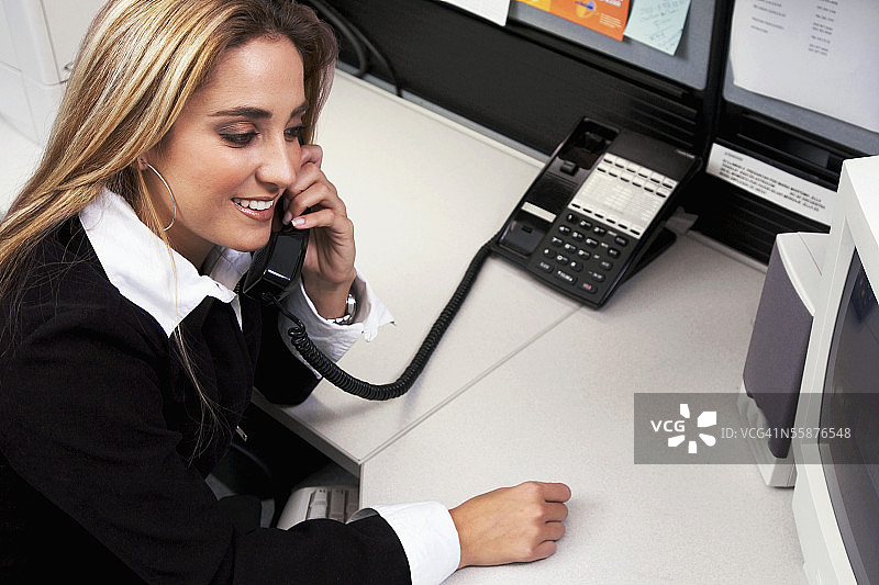 微笑的金发女职员正在打电话图片素材