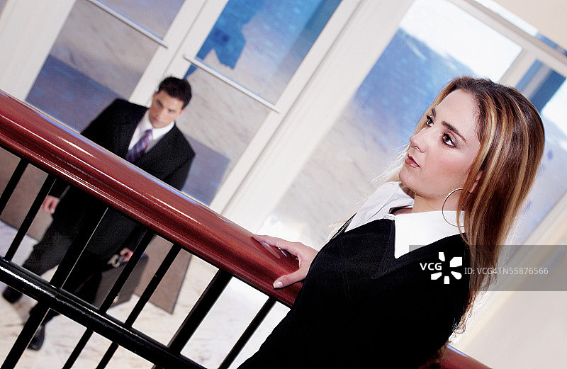 阳台上的女子和楼下提公文包的男子（倾斜视角）图片素材