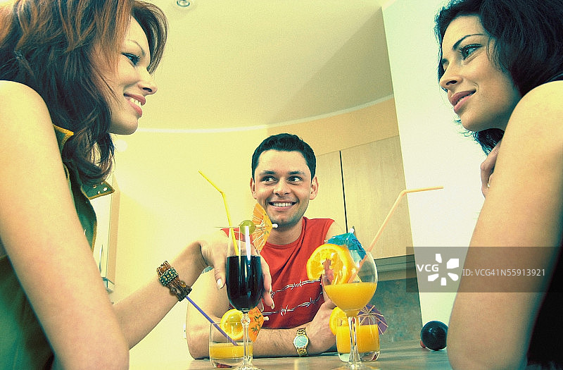 两位中年妇女和一位中年男子享用鸡尾酒的低角度视图图片素材