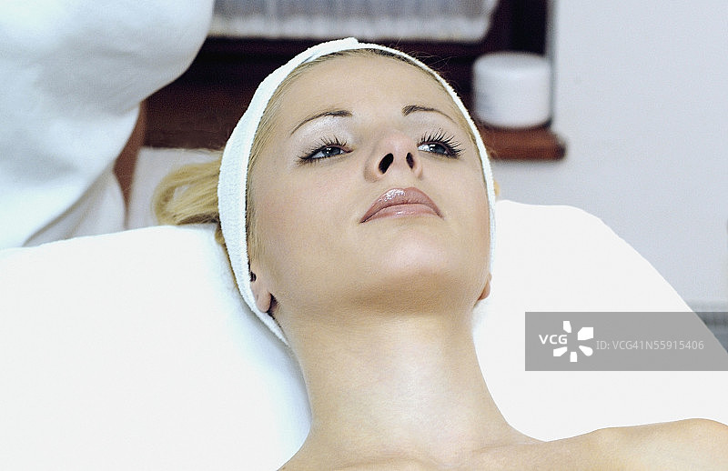 中年妇女躺在按摩台上接受按摩的高角度视角图片素材