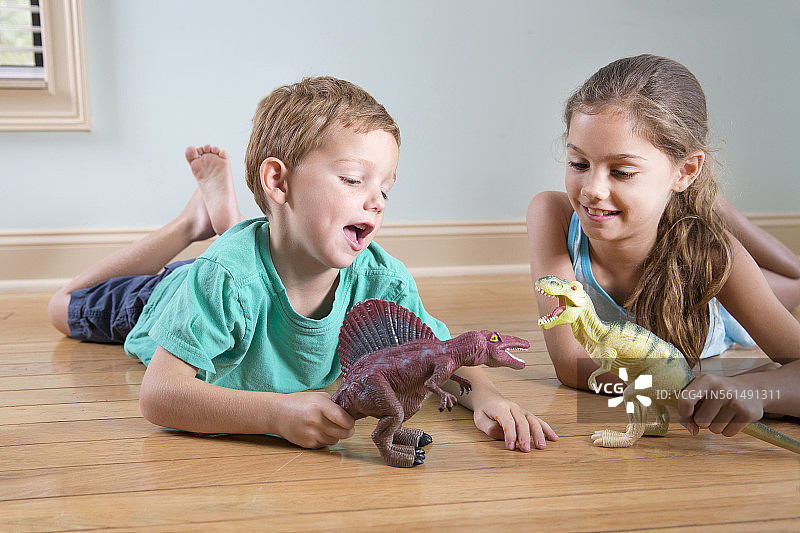 小女孩和男孩玩恐龙玩具图片素材