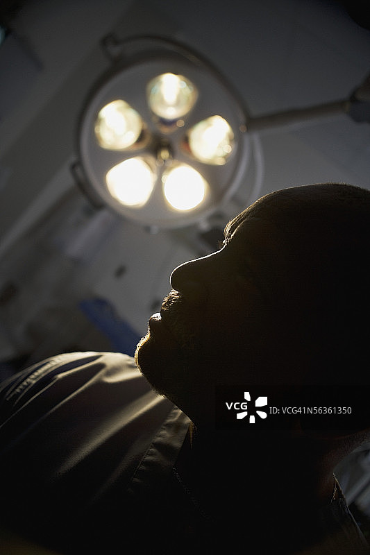 昏暗手术室中的医护人员侧影图片素材