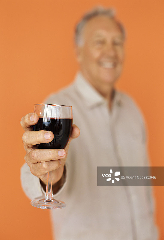 中年男人手持一杯红酒的肖像图片素材
