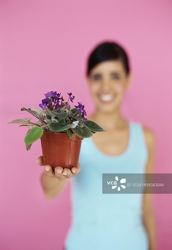 年轻女人手捧盆栽的肖像图片素材