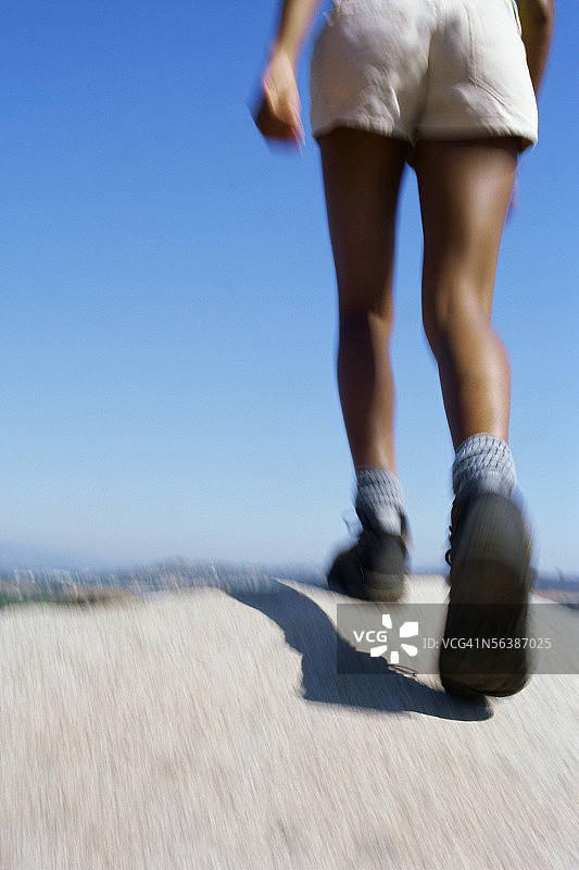 在岩石上行走的人的下半身视角照片图片素材