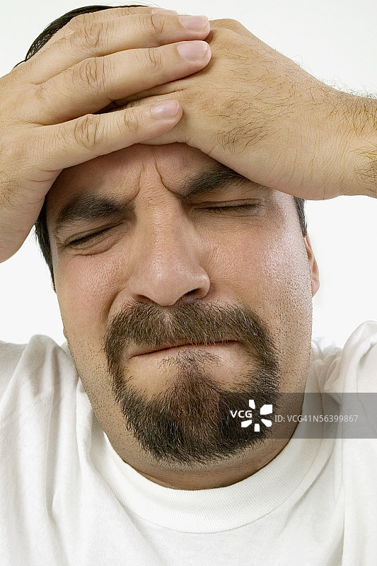 双手紧扣额头的男人图片素材