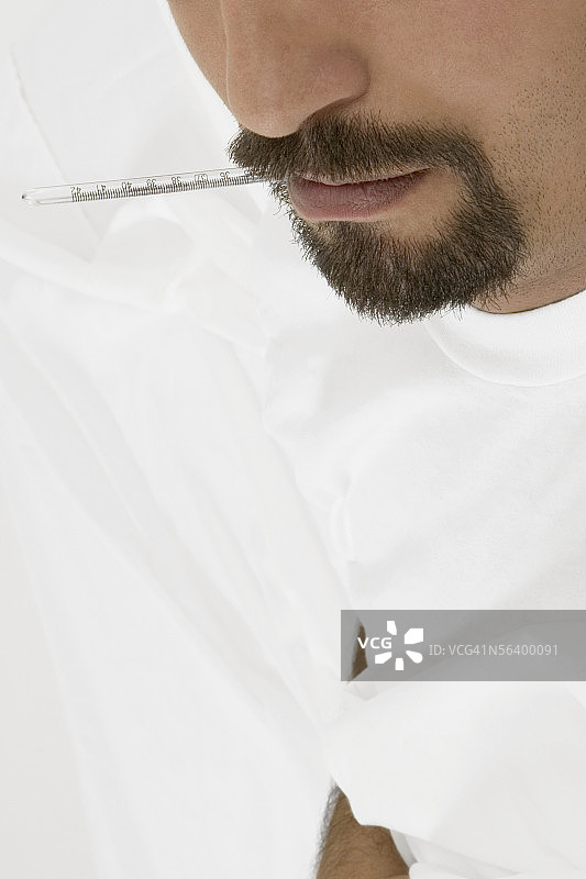 嘴里含着体温计的中年男人图片素材