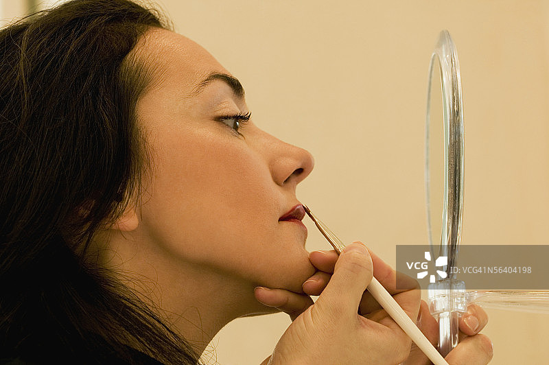 年轻女人侧面像：涂唇线图片素材