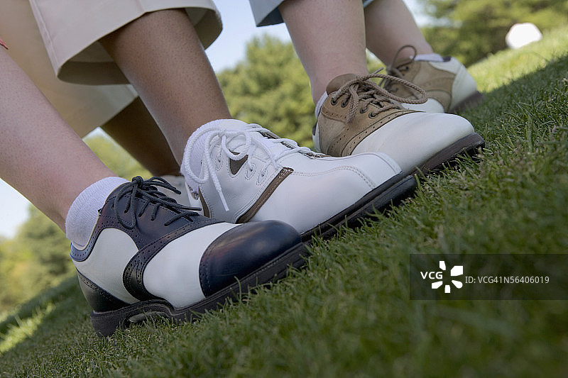 三个穿着高尔夫球鞋的人的下半身视角图片素材
