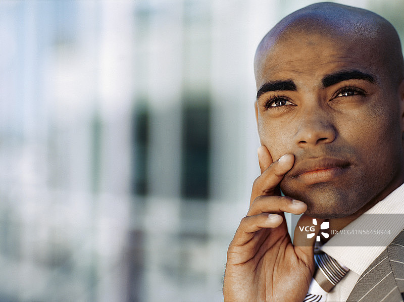 手托下巴思考的男商人特写图片素材