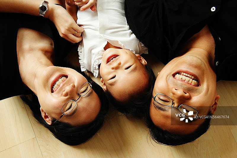 一家人躺在地板上看镜头图片素材