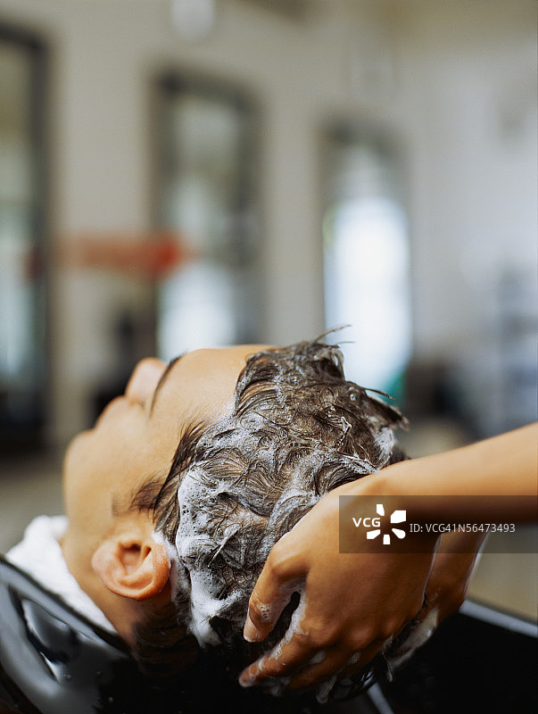 发型师为年轻男人洗头图片素材