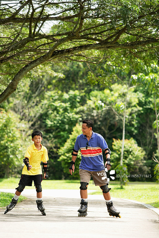 在公园里玩旱冰的父子图片素材
