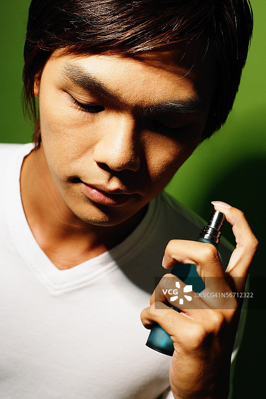 青年手持香水瓶图片素材