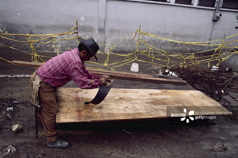 木匠用手锯切割胶合板图片素材