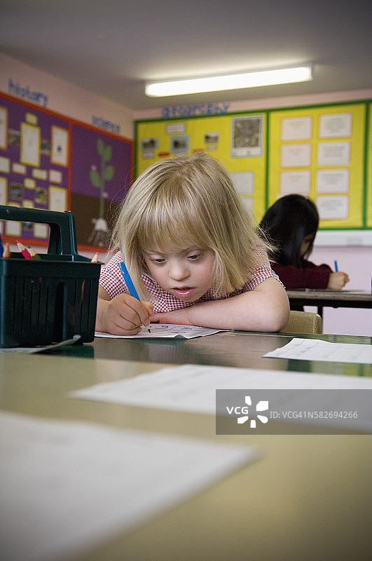 课桌旁的唐氏综合征小学生图片素材