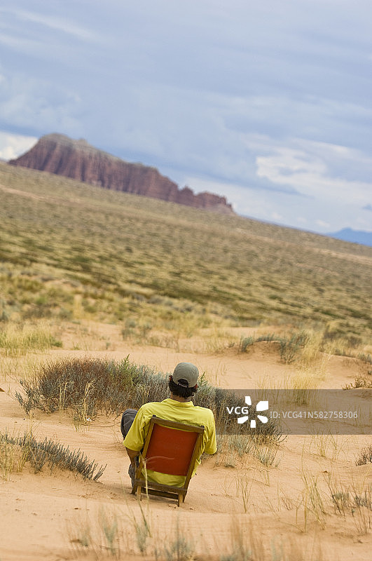 男子坐在沙漠中放松图片素材