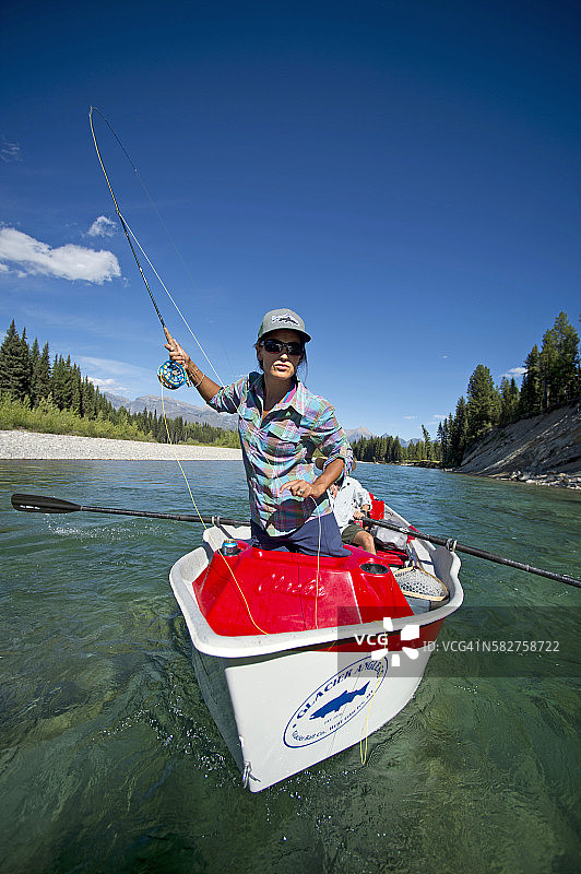 女人在蒙大拿州漂流船上飞蝇钓鱼图片素材