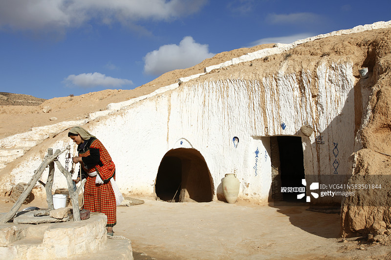 非洲突尼斯玛特玛他穴居人家，柏柏尔地下住宅，妇女在井边图片素材