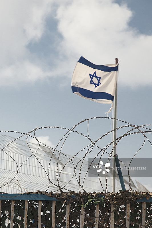 以色列国旗和罗斯哈尼卡拉的带刺铁丝网，位于以色列-叙利亚边境图片素材