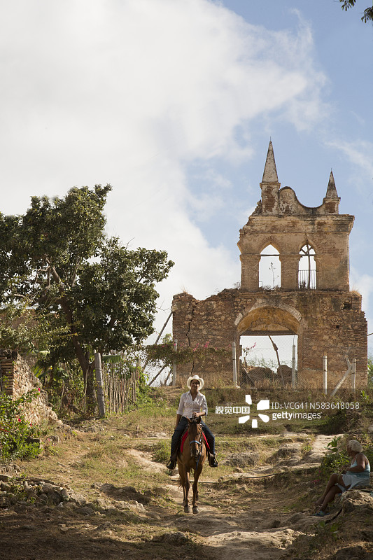 在古巴特立尼达的废墟旁骑马的女人图片素材