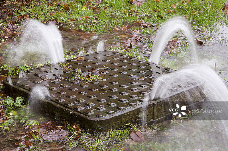 英国湖区安布尔赛德洪水期间，水压将沙井盖顶起图片素材