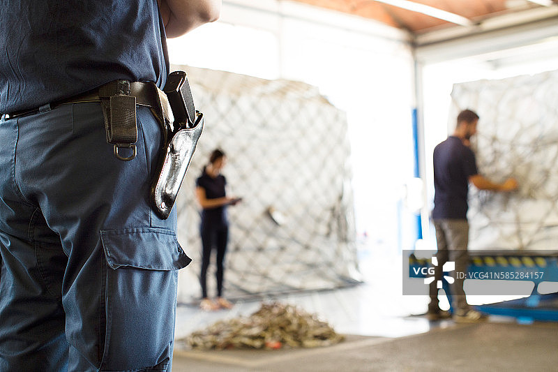 保安在航空货运仓库中监视工人图片素材