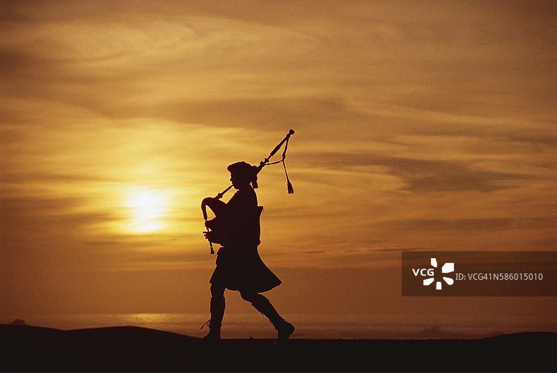 日落风笛手演奏图片素材