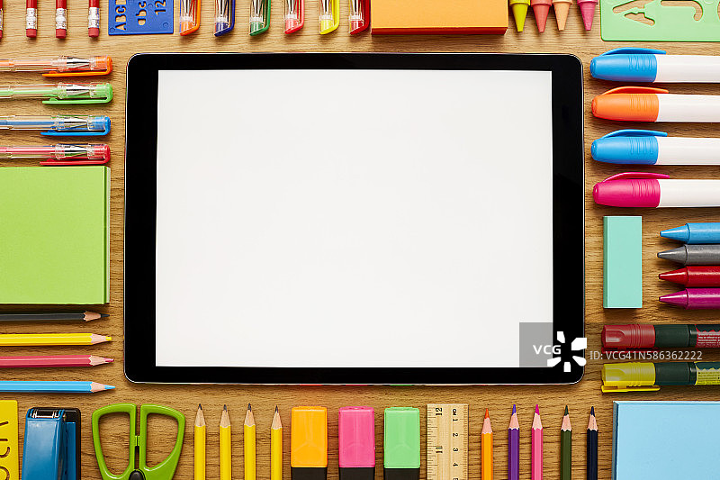桌子上被学习用品环绕的空白数位板图片素材