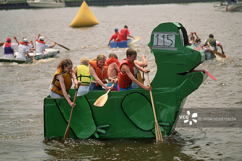 孩子们在比赛中划着纸板船图片素材
