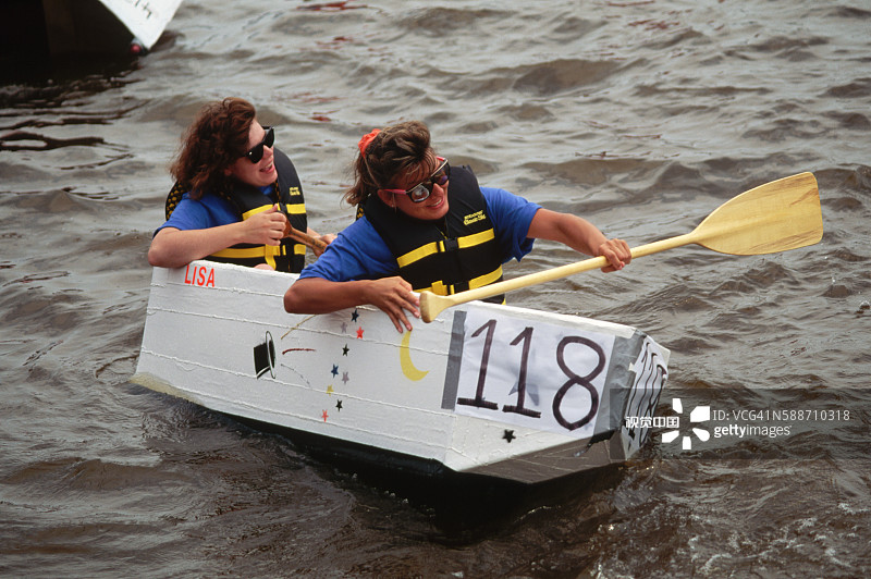 在帆船赛中划纸板船的女士图片素材