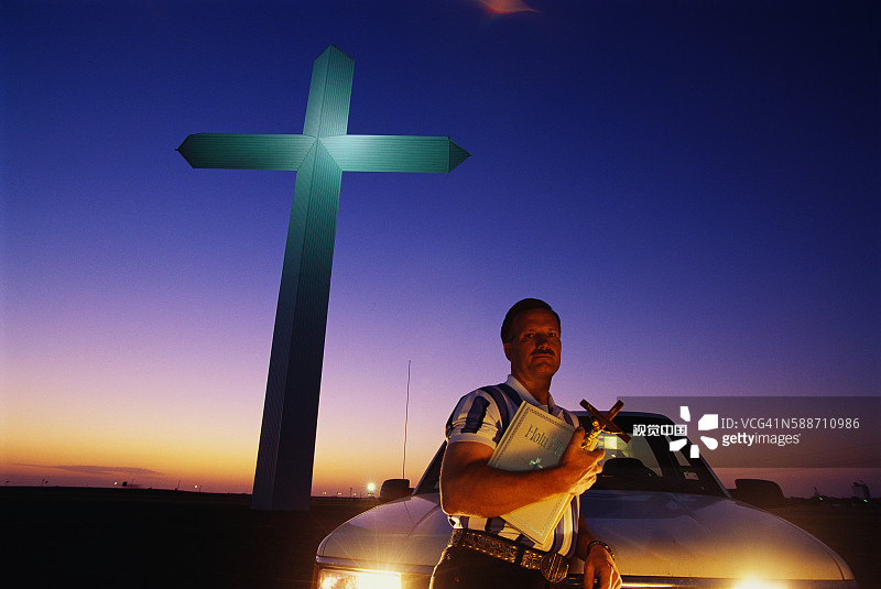 男人手持十字架和圣经图片素材