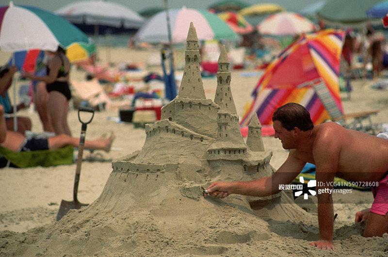 男人在沙滩上建造沙堡图片素材