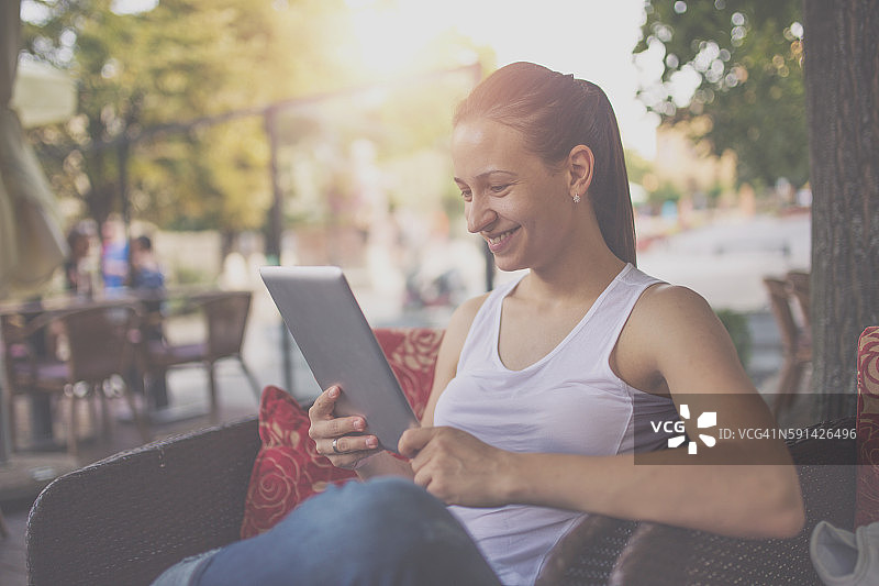 在咖啡馆使用平板电脑的女人图片素材